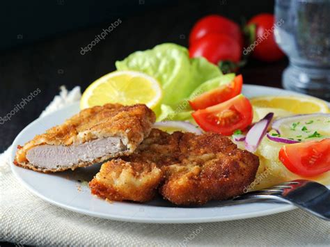 Salchicha Schnitzel con ensalada de patata servida con rodajas de limón