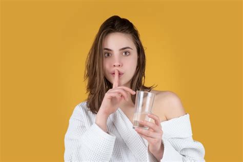 Mujer bebiendo agua dulce aislada en el fondo del estudio niña sostiene