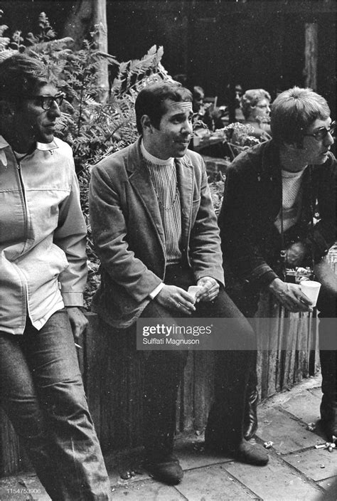 Three Men Sitting On A Bench Talking To Each Other