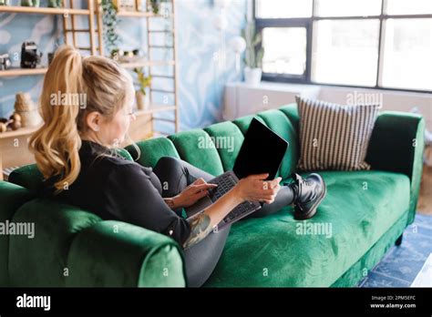 Adult Blonde Woman Lounging On Velvet Couch Holding Laptop Stock Photo Alamy