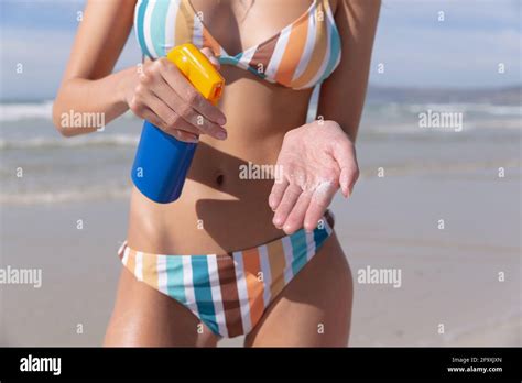 Caucasian Woman Wearing Bikini Putting Sunscreen On At The Beach Stock Photo Alamy