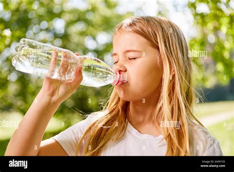 Blonde Girl Is Thirsty And Drinks Mineral Water From A Bottle Stock