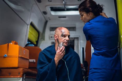 Doctor In Medical Uniform Talks With Man Who Sits In Oxygen Mask In