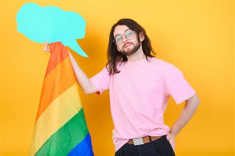 Manos de hombre gay sosteniendo la bandera lgbt en el símbolo lgbt de fondo de la bandera del