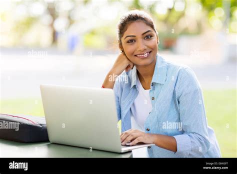 pretty Indian university student using laptop computer outdoors Stock ...