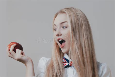 La Jeune Blonde Mignonne Espiègle Mord La Pomme Rouge Image stock Image du âge indicateur