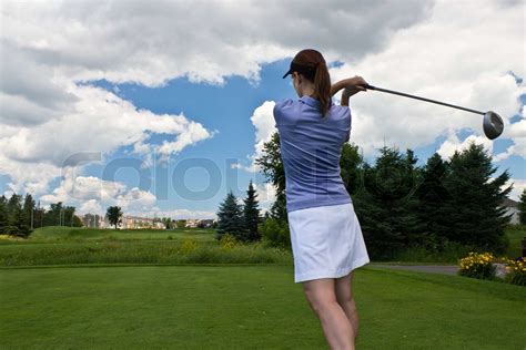 Female golfer swinging her golf club | Stock image | Colourbox