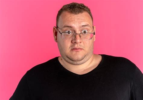 Free Photo Overweight Man In Glasses Wearing Black T Shirt Looking Aside Surprised And Amazed