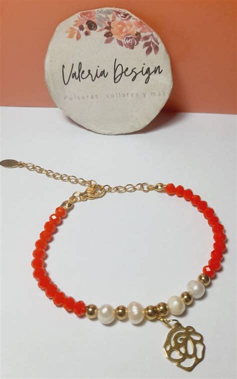 A Bracelet With An Orange Bead And Gold Charm