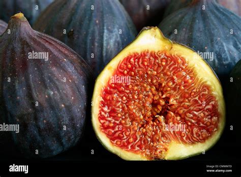 A Close Up Of Ripe Figs With One Cut In Half Showing The Flesh Stock