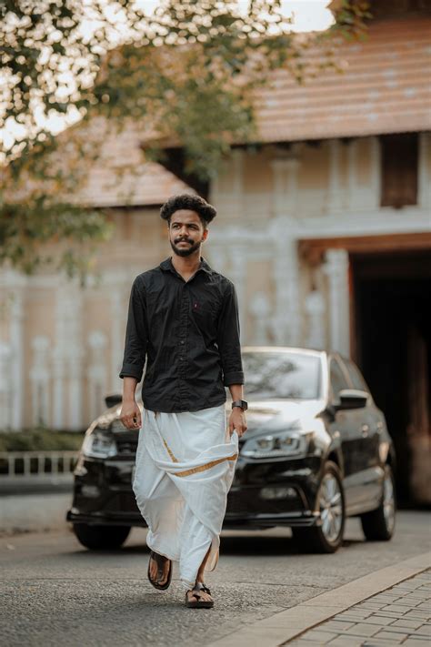 man wearing  dhoti walking  front   car  city  stock photo