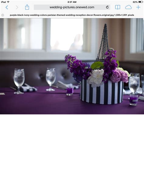 The Table Is Set With Purple And White Flowers In A Striped Hat Shaped