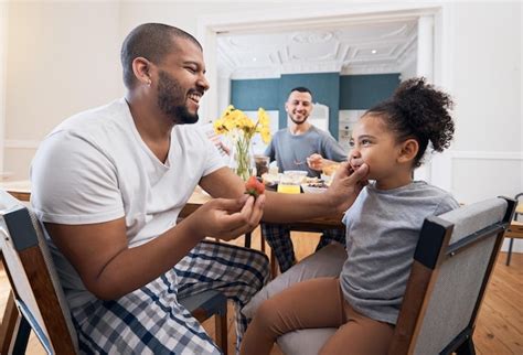 Pareja gay desayuno o niño con el padre limpia limpieza o quita la comida comida de la mañana o