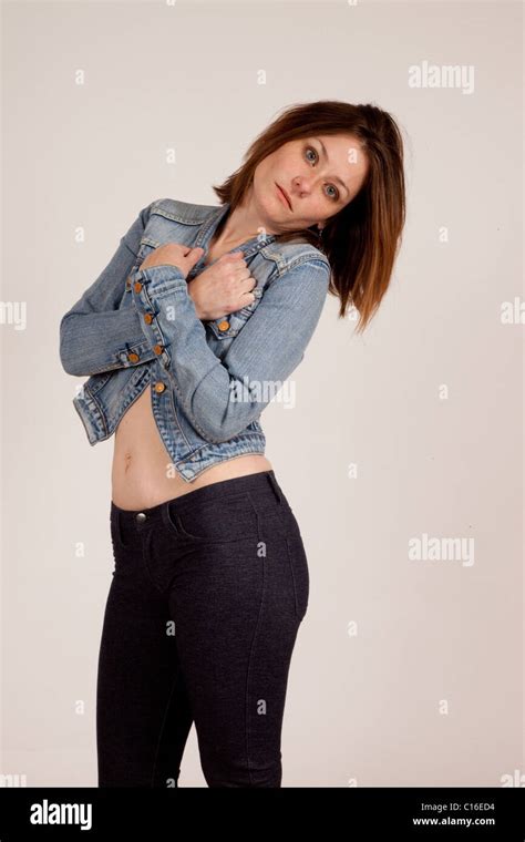 A Pretty Woman Blue Jean Jacket With Her Arms Crossed Across Her Chest