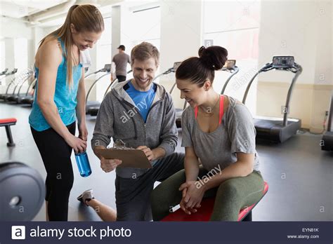 Personal Trainer With Clipboard Talking To Women Gym Stock Photo Alamy