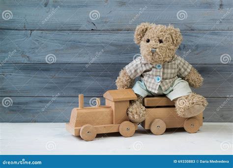 Oso De Peluche Que Se Sienta En El Tren De Madera Del Juguete Fondo De Madera Imagen De Archivo