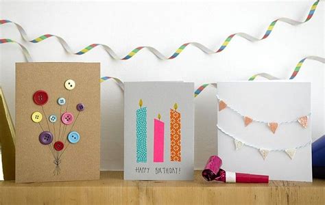 Three Greeting Cards With Buttons On Them Sitting On A Wooden Shelf