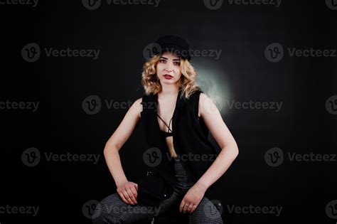 Studio Portrait Of Blonde Girl In Black Wear Bra And Cap Against Dark Background 10484503