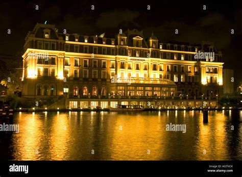 The Amstel Hotel with lights at night along the Amstel River in ...