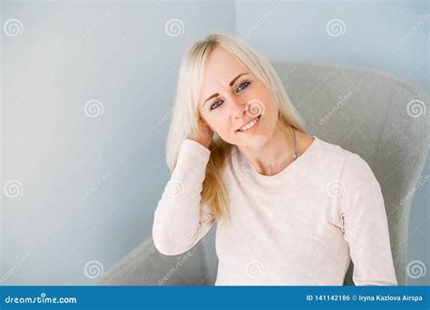 Beautiful Blonde Girl Sitting On Armchair In Light Blue Studio Stock Photo Image Of Sitting