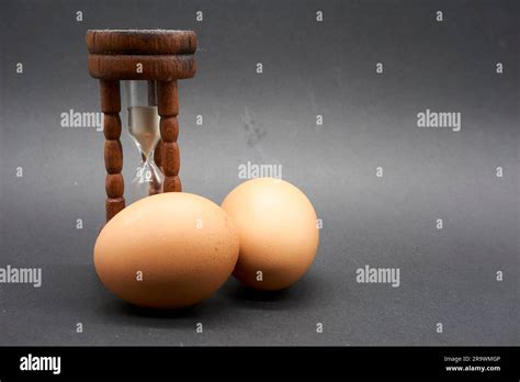 Close Up Of An Antique Hourglass Egg Timer With A Couple Of Eggs Stock