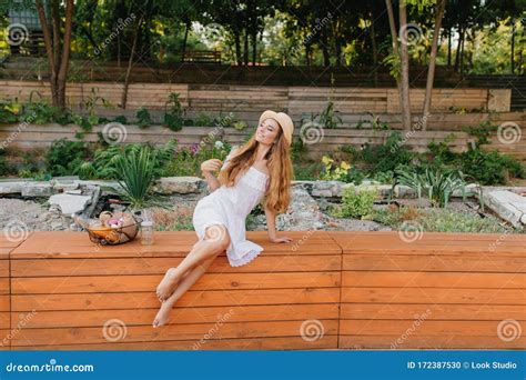 Outdoor Of Dreamy Barefooted Lady With Long Curly Hair Sitting On