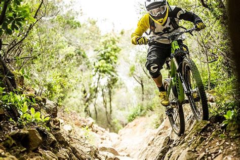 Downhill mountain bike rider navigating a tricky section of a downhill ...