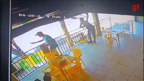 Vídeo Câmera flagra homem sacando arma e apontando para casal em bar