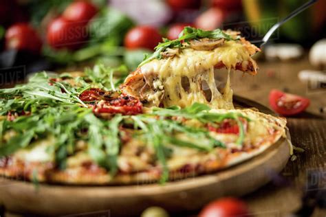 Close Up Of Sliced Hot Italian Pizza With Fresh Arugula Stock Photo