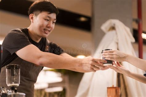 Asian Man Coffee Maker Handing Over A Cup Of Coffee Served To Female