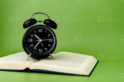 black alarm clock Put on an open book, reading ideas and reading time ...