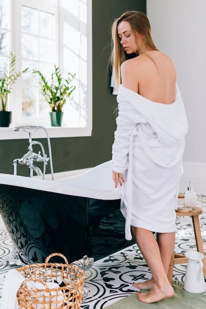 Femme Blonde Qui Pose Dans La Salle De Bain Avec Un Peignoir Photo Gratuite