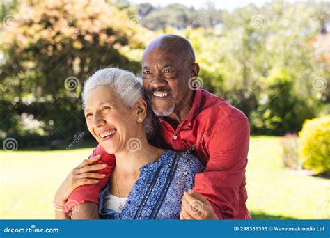 Happy Diverse Senior Couple Embracing In Sunny Garden Stock Image Image Of Diverse Male