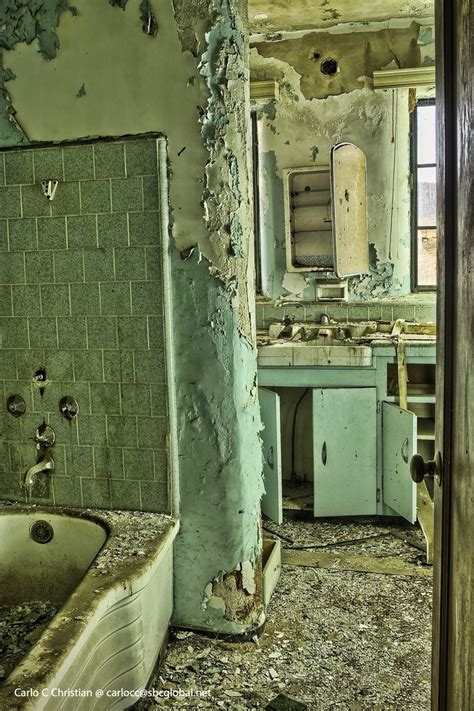 An Old Run Down Bathroom With Peeling Paint On The Walls And Tub In The