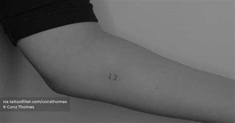 Tiny tattoo of the number "13" placed on the inner