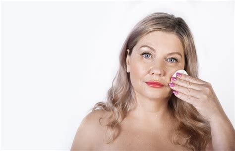 Premium Photo Adult Blonde Woman Cleaning Her Face With A Cotton Disk Posing With Naked