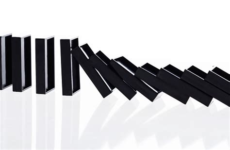 A Row Of Black Dominos Falling Down Stock Photo Download Image Now