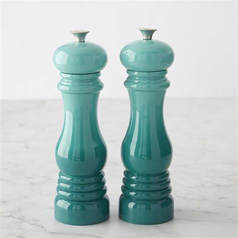 Two Green Salt And Pepper Shakers On A Marble Counter