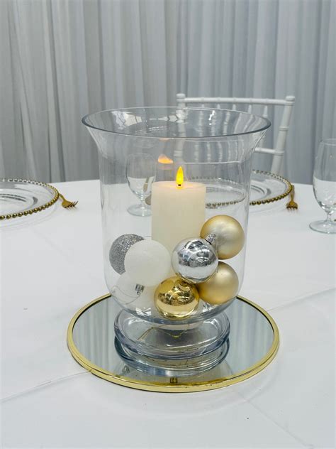 Hurricane vase with LED pillar candle and baubles - Weddings of Distinction