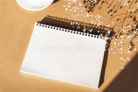 Mock Up Of Blank Notepad On Orange Background With Gypsophila Flowers