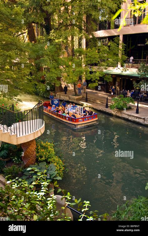 San Antonio River Walk riverwalk tour boat with tourists passes beside ...