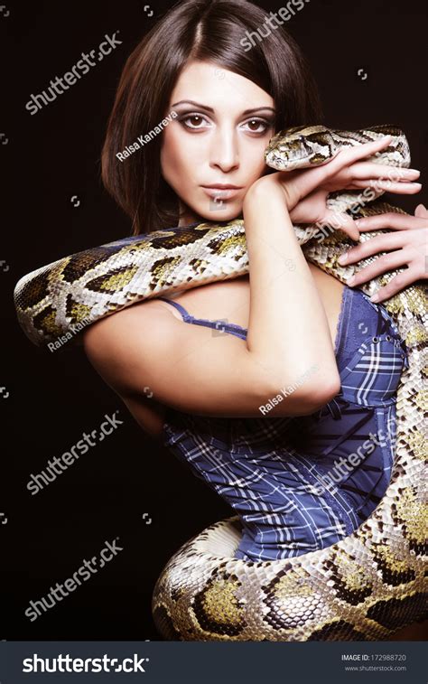 Sexy Brunette Holding Python Over Black Stock Photo