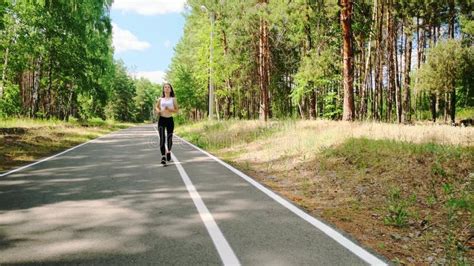 Sportwomen Runner Jogging In Forest Girl Brunette Enjoys Jogging Outdoors Stock Video Video
