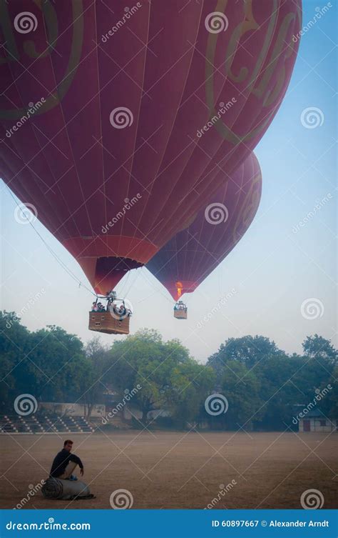 Asian Man Sitting In Front Of Two Hot Air Balloons Editorial