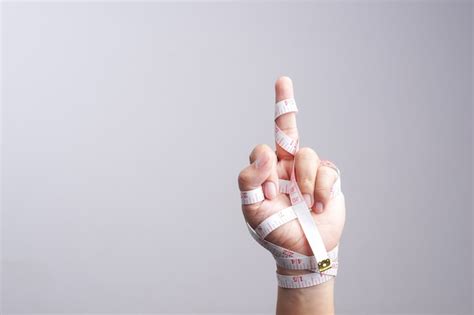 Premium Photo Hand With Fuck You Gesture Wrapped By Measuring Tape