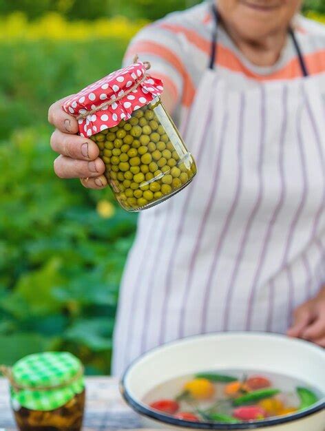 Premium Photo Senior Woman Preserving Vegetables In Jars Selective Focus