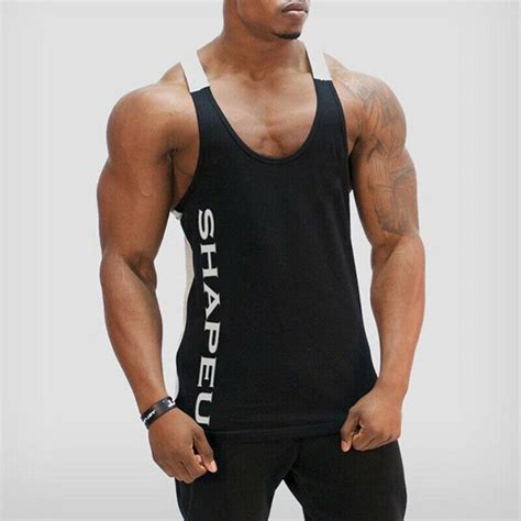 a man wearing a black tank top with white writing on it and his hands ...