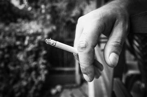 Premium Photo Close Up Of Hand Holding Cigarette