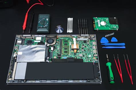 Disassembled Laptop With Computer Parts And Special Tools Stock Photo