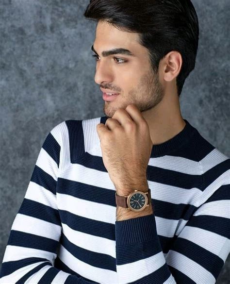 A Man With A Watch On His Wrist Looking Away From The Camera While